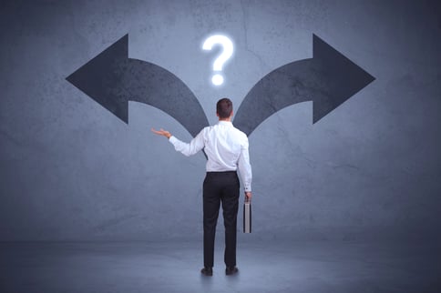 Businessman taking a decision while looking at arrows on the wall concept background